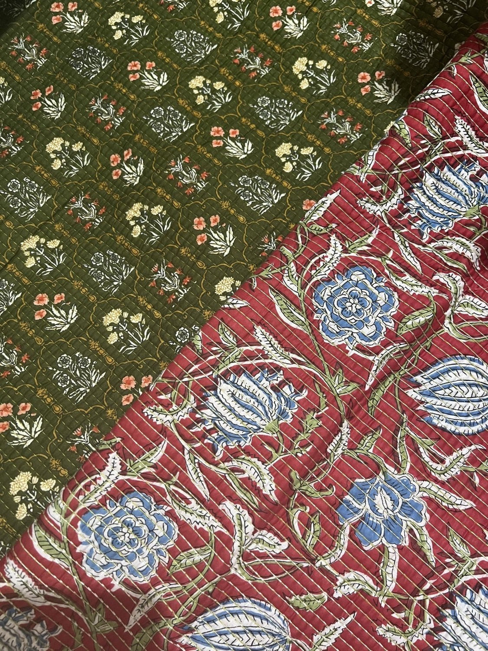 Tela acolchada doblada para ver sus dos caras: flores menudas sobre verde oliva y flores grandes sobre granate